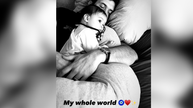 Ileana, on Monday, morning took to Instagram stories, where she uploaded a monochrome picture of her son resting on Dolan, who is asleep in bed. Little Koa is on his father’s lap, wide awake